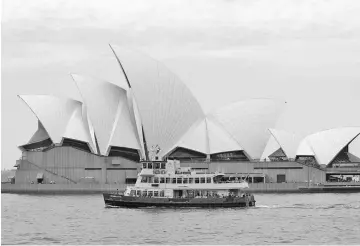  ?? — WP-Bloomberg photo ?? A ferry sails past the Sydney Opera House in Sydney, Australia, on Apr 29, 2016.