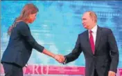  ??  ?? Vladimir Putin shakes hands with a TV host as he arrives for his annual televised callin show in Moscow on Thursday.