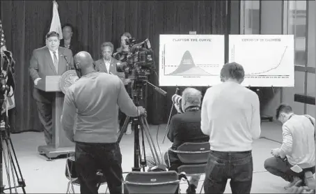  ?? CHRIS SWEDA/CHICAGO TRIBUNE ?? Gov. J.B. Pritzker, flanked by Chicago Mayor Lori Lightfoot, conducts a briefing on COVID-19 from the Thompson Center on March 20 in Chicago.