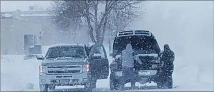  ?? JIM MONK/KFGO RADIO, FARGO VIA AP ?? Residents in Fargo, N.D., attempt to jump-start a vehicle with a dead battery in the middle of a snowstorm on Saturday.