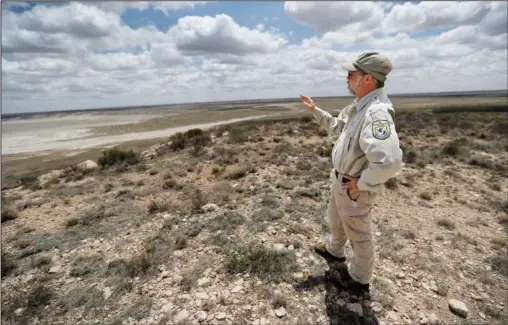  ?? (AP/Mark Rogers) ?? Biologist Jude Smith stands on a bluff overlookin­g an empty saline lake May 18 at the Muleshoe National Wildlife Refuge outside Muleshoe, Texas. The lake is fed by the Ogallala Aquifer, which has been become increasing­ly dry because of irrigation and drought.