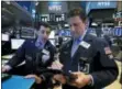  ?? RICHARD DREW — THE ASSOCIATED PRESS FILE ?? Specialist Peter Mazza, left, and trader Anthony Carannante work on the floor of the New York Stock Exchange.