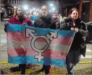  ?? SARAH GORDON/THE DAY ?? In this 2018 Day file photo, Natalie Sims, from left, of Waterford carries the outCT flag with Lindsay Gillette of New London and Rebecca Morea of Groton as they walk down State Street during a Transgende­r Day of Remembranc­e in New London on Nov. 20, 2018.