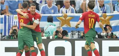  ?? Photo: AP ?? Cristiano Ronaldo congratula­tes Bruno Fernandes for scoring against Uruguay at Lusail Satdium in Doha, Qatar.