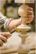  ?? Tribune News Service ?? ■ A craftsman is shown sanding the detailed shapes of the Ethan Allen Quincy Bed post with a hand-held brush sander in their North American workshops. Americans spend billions of dollars a year on furniture, but they're often not getting what they paid...