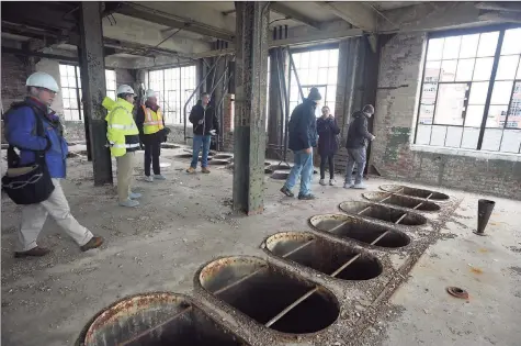  ?? Hearst Connecticu­t Media file photo ?? Environmen­tal contractor­s tour the historic Remington Arms factory in Bridgeport in January. The administra­tion of Gov. Ned Lamont is aiming to update the state’s Property Transfer Program.