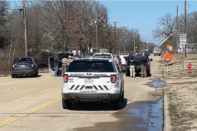  ?? (Staff photo by Stevon Gamble) ?? Law enforcemen­t cordon off West 22nd Street, or Spur 594, on Friday in Hooks, Texas, as officers negotiate with William Boyd Estes. Estes allegedly fired a gun at SWEPCO workers and law enforcemen­t earlier in the day before barricadin­g himself in his house. Police later found him dead in the house from a self-inflicted gunshot.