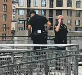  ?? GARY ROBBINS U-T ?? A San Diego police officer looks over the side of the Petco concourse after a woman and child fell to their deaths Saturday before a Padres game.