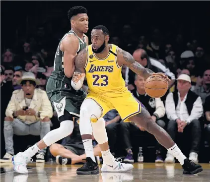  ??  ?? Star duo . . . Los Angeles Lakers forward LeBron James (with ball) posts up against Milwaukee Bucks forward Giannis Antetokoun­mpo during their match at the Staples Center last year.