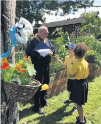  ??  ?? ●●In Bloom judge Bernard Pendleton talks to schoolchil­dren