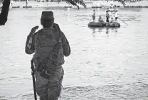  ?? Staff file photo ?? The actions of Mexican authoritie­s, such as this national guard member monitoring travelers from Guatemala, play a large role in the success or failure of immigrant caravans.