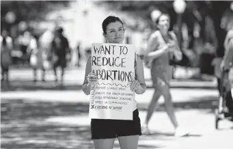  ?? Kin Man Hui/Staff photograph­er ?? Paloma Amayo-Ryan protests alone Friday at the Texas Capitol as abortion supporters react to the Supreme Court decision to overturn Roe vs. Wade outside Austin's federal courthouse.