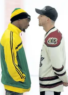  ?? CLIFFORD SKARSTEDT/EXAMINER ?? Local boxer Cody Crowley faces off at centre ice with Jamaica's Richard (The Frog) Holmes to promote their internatio­nal title bout, taking place Saturday night at the Memorial Centre, during a puck dropping ceremony before the start of the...