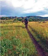  ??  ?? Photo shows Ryan Johnson leading Drew Redman on the single-track trail that makes the Maah Daah Hey Trail, in western North Dakota, a popular destinatio­n for mountain bikers.