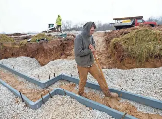  ?? MIKE DE SISTI / MILWAUKEE JOURNAL SENTINEL ?? Jacob Danby, with Coello & Associates of Waukesha, clears dirt Tuesday at the site of a home being built by Belman Homes in the Rolling Oaks II neighborho­od in Waukesha.