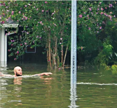  ??  ?? Top: a man evacuates his family and their pets from their flooded Meyerland home in Houston.
From left: a mobile home park was left devastated; householde­rs watch the rain in the Cottage Grove neighbourh­ood of Houston; Wilford Martinez, right, is...