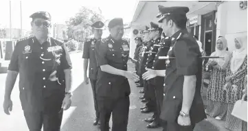  ??  ?? Fuzi (centre) with Omar (left) meeting officers and members of Kunak police headquarte­rs.