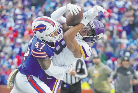  ?? Joshua Bessex
The Associated Press ?? Vikings receiver Justin Jefferson makes a circus catch under coverage from Buffalo cornerback Christian Benford, one of his 10 receptions on Sunday.