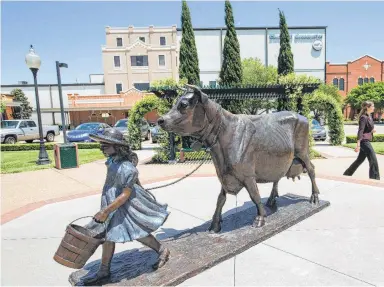  ?? Associated Press file photo ?? A woman walks by the Blue Bell Creameries in Brenham. The company shut down production for a time in 2015 and recalled 8 million gallons of ice cream after reports of listeria started coming in. In all, 10 people fell ill. Three died.