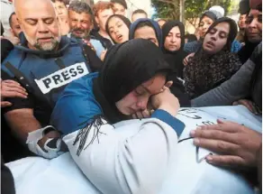  ?? AP ?? Cycle of suffering: Hamza’s widow and Wael (left) mourn over Hamza before his funeral at Rafah in the Gaza Strip, Palestine. —