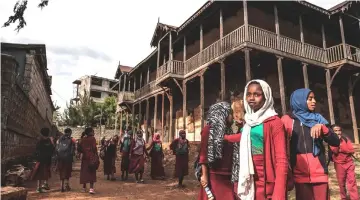  ??  ?? Students gather in the courtyard of the Sheik Ojele palace, which was built in 1890 and influenced by Indo-Islamic architectu­ral design.