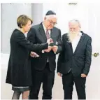  ?? FOTO: DPA ?? Frank-Walter Steinmeier, Elke Büdenbende­r und Yehuda Mansbach zünden die Kerzen an.