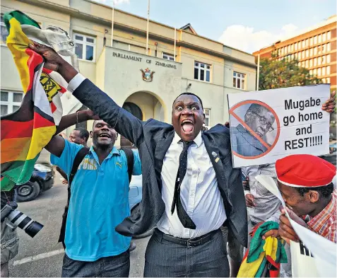  ??  ?? Zimbabwean­s celebrate outside the parliament building in Harare after hearing the news that Robert Mugabe had finally resigned as president after 37 years in power