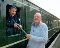  ?? ?? Above: Bob Richards, holding the signalling staff tube he used in 1972, with Peter Frost at Corfe Castle on Saturday, January 1, 2022. ANDREW PM WRIGHT