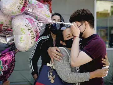  ?? Nelvin C. Cepeda San Diego Union-Tribune ?? BRYAN CHAVEZ covers his tearful face as he is reunited with mother Sandra Ortiz in San Diego on May 4. They were separated in 2017 and she was sent to Mexico. A judge in 2019 ordered counseling for such families.