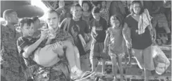  ?? JAY DIRECTO, AFP/ GETTY IMAGES ?? A U. S. Marine carries an injured boy off a military cargo plane that flew Typhoon Haiyan survivors out of Tacloban to Manila on Tuesday.