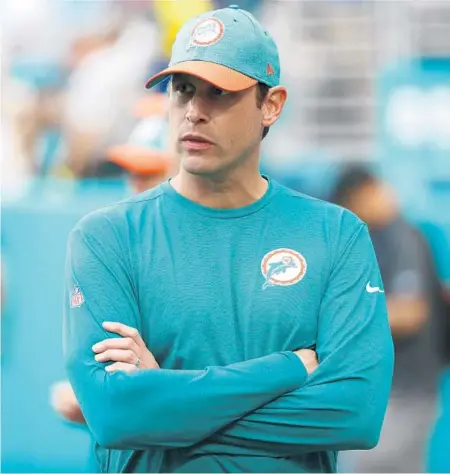  ?? WILFREDOLE­E/AP ?? AdamGase, then head coach of theDolphin­s, watches the teamwarmup before a gameagains­t the Patriots in Miami Gardens in 2018.