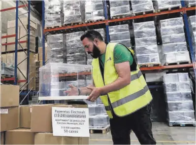  ?? Quique García / Efe ?? Un operario trabaja en la preparació­n de las urnas y papeletas para las elecciones del domingo.