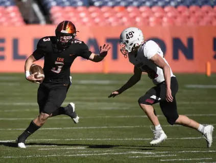  ?? Andy Cross, The Denver Post ?? Erie quarterbac­k Blake Barnett, left, stiff arms Chatfield defender Dakota Balderson on a keeper in the first quarter of the Class 4A championsh­ip game on Saturday.