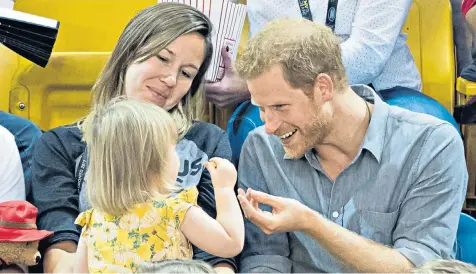  ??  ?? Snack and grab: Emily Henson, two, got away with poaching Prince Harry’s popcorn for nearly a minute at the Invictus Game in Toronto before the Prince realised