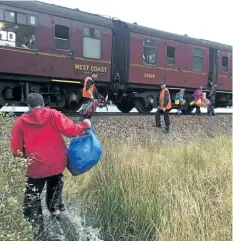  ?? PHOTO COURTESTY JON CLUETT ?? In this photo taken on Oct. 13, children run towards a train near Loch Eilt in the Scottish Highlands. The Hogwarts Express came to the rescue of a stranded family in Scotland last week.