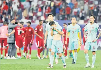  ?? — AFP photo ?? China’s players (right) react after the match.