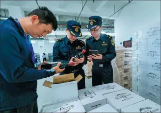 ?? XU YU / XINHUA ?? Customs officials check imported wines in Lishui, Zhejiang province.