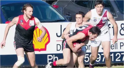  ??  ?? Warragul’s Nic Mulqueen tries to burst through a Traralgon tackle during Saturday’s match at Western Park as team mate Aiden Maric moves in to lend a hand.