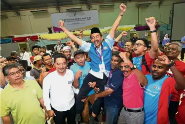  ??  ?? Proud moment: Zawawi with supporters after winning the Sungai Kandis seat at the counting centre in Shah Alam.