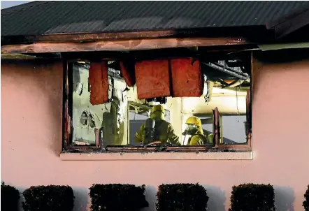  ?? HELEN NICKISSON/STUFF ?? Firefighte­rs work in the kitchen of a Witherlea home in Blenheim, where a blaze caused severe damage last week.