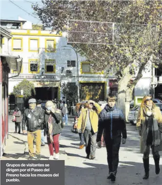  ?? ?? Grupos de visitantes se dirigen por el Paseo del Fresno hacia los museos del pueblo.