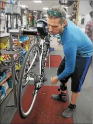 ?? GENE WALSH — DIGITAL FIRST MEDIA ?? Store manager Zach Landes, works on a bike at Scooter’s Bike Shop in Souderton.