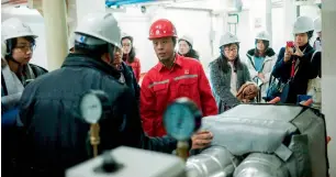  ?? AFP ?? A Sinopec employee with journalist­s during a media tour. Sinopec appears to be investing further in renewable energy, including solar and wind, as well as geothermal. —