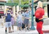  ?? JOE BURBANK/ORLANDO SENTINEL ?? Guests wave to Mr. Incredible during a pop-up appearance of Pixar characters at Disney’s Hollywood Studios.