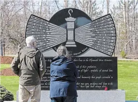  ?? ANDREW VAUGHAN THE CANADIAN PRESS ?? Visitors pay their respects at a memorial park in New Glasgow, N.S. on Monday, marking the 30th anniversar­y of the Westray coal mine disaster that claimed 26 lives.