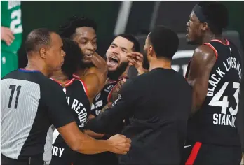  ??  ?? The Associated Press
Teammates mob Toronto Raptors’ OG Anunoby, second player from left, after Anunoby’s game winning shot at the buzzer in an NBA conference semifinal playoff basketball game against the Boston Celtics Thursday.