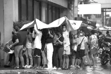  ?? The STAR / Miguel De Guzman ?? People queue outside SM City Sta. Mesa in Quezon City to register for the upcoming December 2022 barangay elections despite the light rainfall on Thursday.