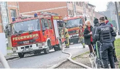  ?? ?? Mehrere Rettungsfa­hrzeuge blockieren während der Löscharbei­ten die Straße. Der Einsatz erregt am Freitag großes Aufsehen.