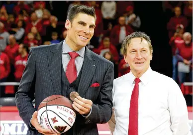  ?? CONTRIBUTE­D BY MIAMI UNIVERSITY ?? Miami legend Wally Szczerbiak displays his medal for embodying the school’s “Love and Honor” motto and a basketball listing some of his accomplish­ments with Athletic Director David Sayler on Friday night.