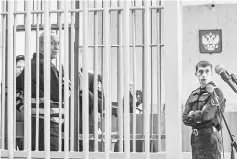  ??  ?? Mikhail Popkov stands inside a defendants’ cage during a court hearing in Irkutsk. — AFP photo